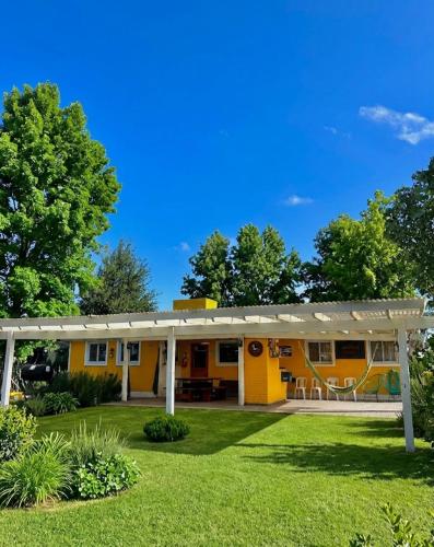 a yellow house with a pergola at BARRIO VIEJO in Los Reartes