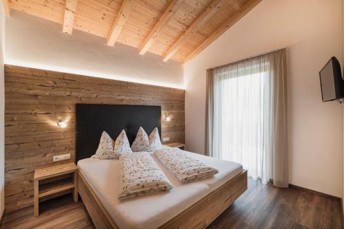 a bedroom with a large bed with white pillows at Chalet Schaller in Missiano