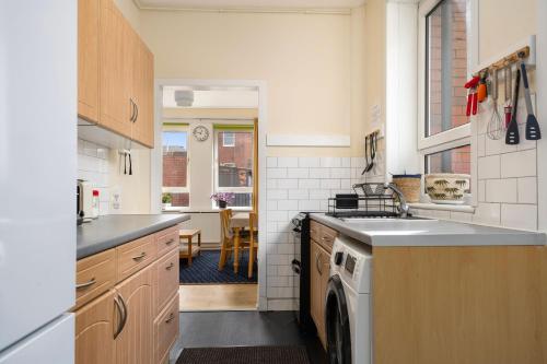 a kitchen with a sink and a dishwasher at Hotspur House in Glasgow
