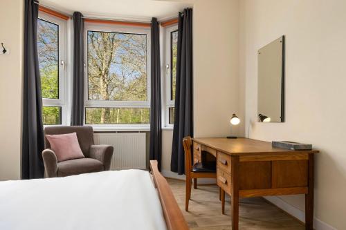 a bedroom with a desk and a bed and a chair at Hotspur House in Glasgow
