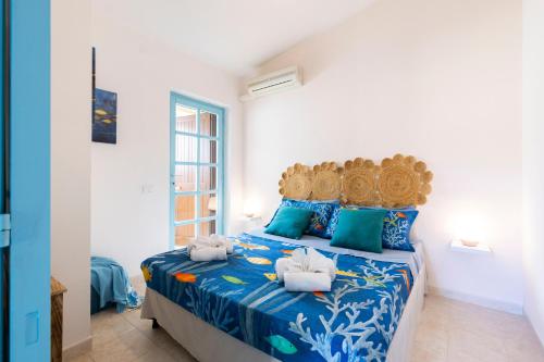 a bedroom with a bed with blue and white sheets at Blue View - A Due Passi dal Mare & Natura in Quartu SantʼElena