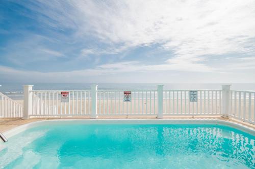 a swimming pool on a balcony with the ocean in the background at Saltwater Blessing by Oak Island Accommodations in Oak Island