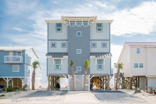 a tall building with palm trees in front of it at Saltwater Blessing by Oak Island Accommodations in Oak Island