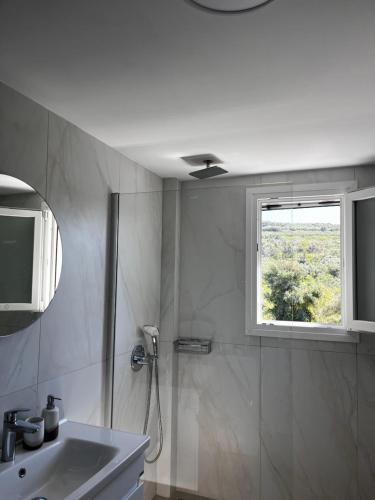 a bathroom with a shower and a sink and a window at Elaya Experience in Kamisianá