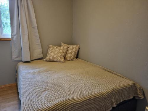 a bed in a room with two pillows on it at Cozy cabin close to nature in Sorreisa