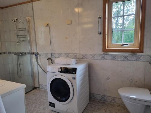 a washing machine in a bathroom with a toilet at Cozy cabin close to nature in Sorreisa
