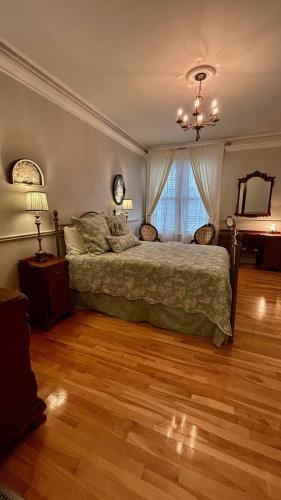 a bedroom with a bed and a mirror and a piano at Maison Jodoin - Suite Albert in Saint-Hyacinthe
