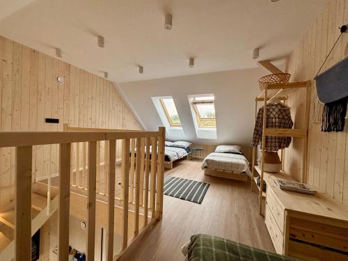 a room with wooden walls and a staircase with a bed at Winnica Przybysławice in Przybysławice