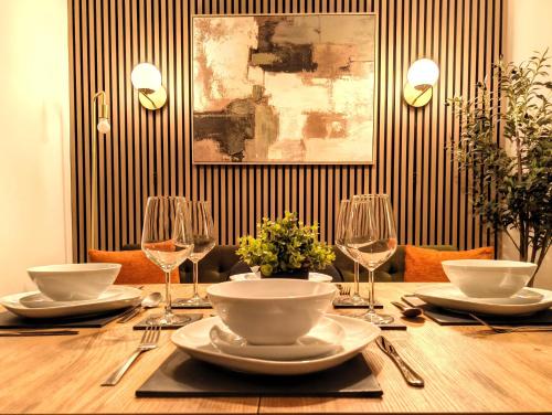 a wooden table with plates and wine glasses on it at Sea Breeze in Bournemouth