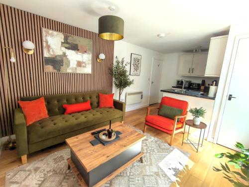 a living room with a green couch and red pillows at Sea Breeze in Bournemouth