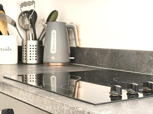 a kitchen counter with a stove with a kettle on it at Sea Breeze in Bournemouth
