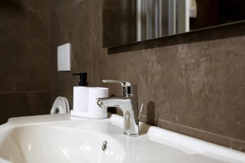 a bathroom sink with a faucet and a mirror at Caudium B&B in Montesarchio