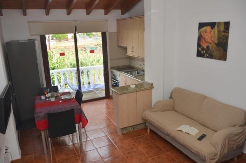 ein Wohnzimmer mit einem Sofa und einem Tisch sowie eine Küche in der Unterkunft Casa Antonio in Valle Gran Rey