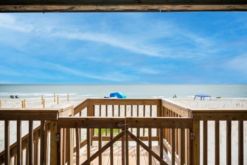 a wooden deck on a beach with the ocean in the background at Blue Haven by Oak Island Accommodations in Oak Island