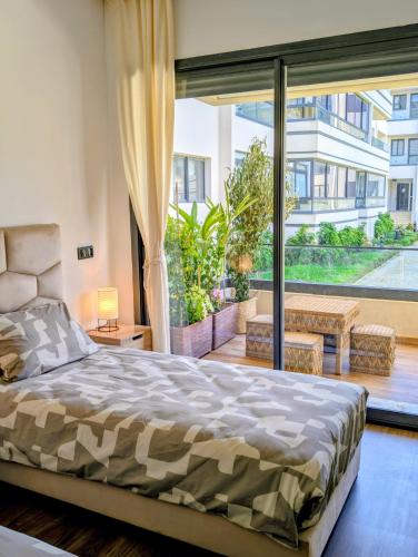 a bedroom with a bed and a large window at Pool view apartment, beach access, nature & quiet in Mansouria