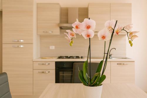 a vase of flowers on a table in a kitchen at Sole e Luna in San Vito