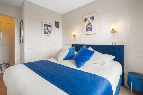 a bedroom with a blue and white bed with blue pillows at Magic Blue Paris à Disneyland in Serris