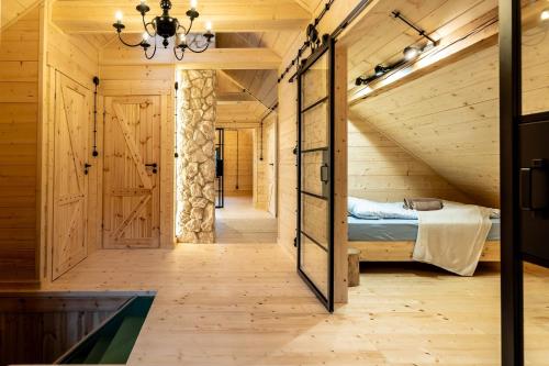 a bedroom with a bed in a wooden house at Kamp Soblówka in Sablówka