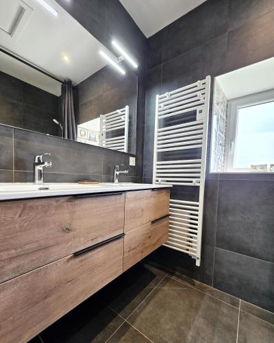 a bathroom with a sink and a mirror at Gite Les Petits Monts in Commes
