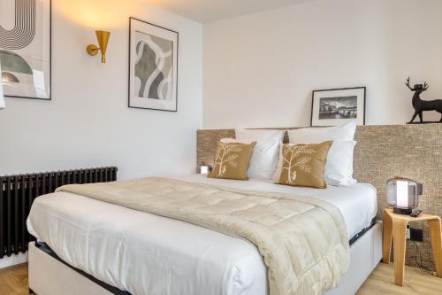 a bedroom with a large white bed with pillows at Paris Central Gem 9 Min Walk to Notre-Dame and Louvre in Paris