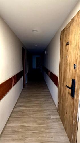 an empty hallway with a wooden door in a building at Kopa9 in Palanga