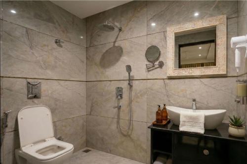 a bathroom with a shower and a toilet and a sink at Swaranjali in Chikhli