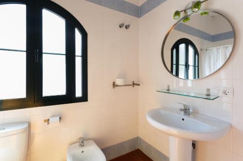 a bathroom with a sink and a mirror and a toilet at Camping la Sierrecilla in Humilladero