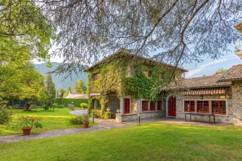 an old stone house with a green yard at Villa Colle in Ossuccio