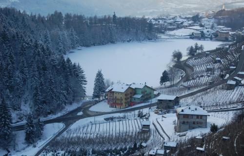 a small town with a lake in the snow at Residence Hotel Miralago in Pergine Valsugana