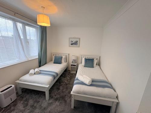 two twin beds in a room with a window at Sycamore haven in Spinney Hill