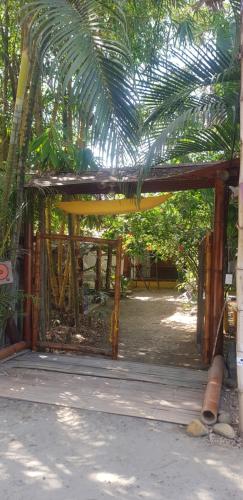 ein Gebäude mit einer Holzkonstruktion und einem Zaun in der Unterkunft Bongosurfcamp in Mompiche