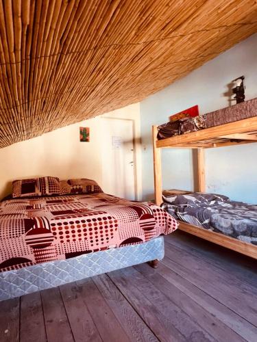 a bedroom with two bunk beds and a wooden floor at El Farolo in Tilcara