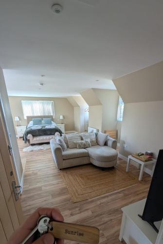 a living room with a couch and a bed at The Wimpey At Mill Cottage in Bedford