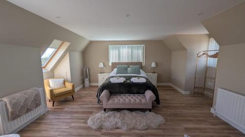a bedroom with a large bed and a chair at The Wimpey At Mill Cottage in Bedford