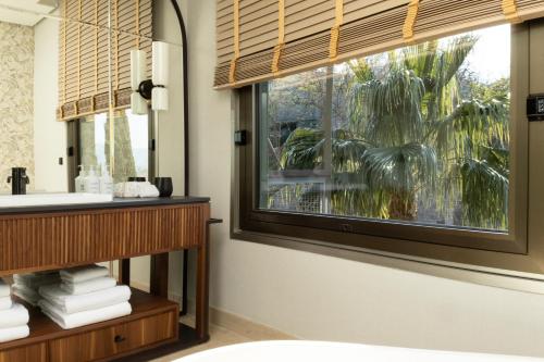 a bathroom with a window with a sink and a mirror at Hotel Miramar Barcelona GL - LVX Preferred Hotels & Resorts - Newly Renovated in Barcelona