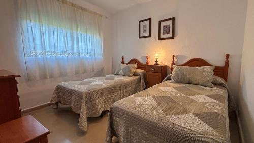 a bedroom with two beds and a window at Casa La Cañada by CasaTuristica in Ronda