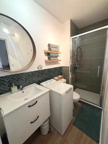 a bathroom with a sink and a toilet and a mirror at À 1min à pied de la mer, studio lumineux & cosy in Carnon-Plage