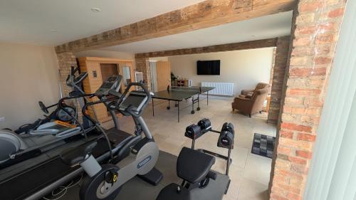a living room with a gym with a treadmill at The Wimpey At Mill Cottage in Bedford