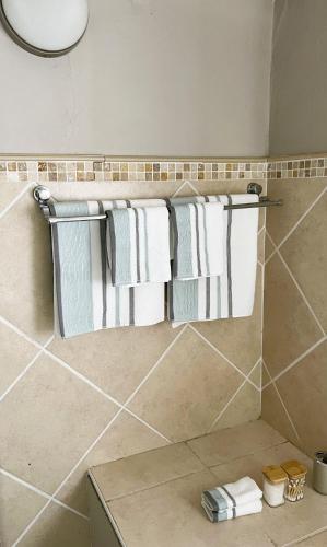 a bathroom with white towels hanging on a wall at 29 Village Place in Gaborone
