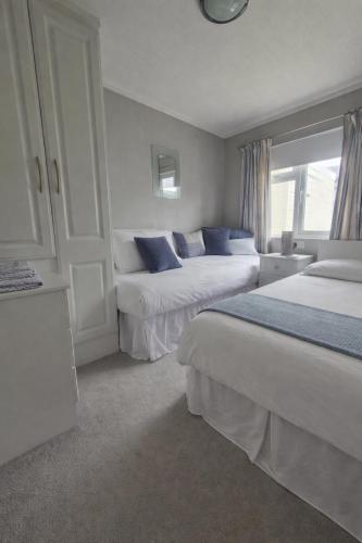 a hotel room with two beds and a window at P1 The Warren Abersoch in Llanbedrog
