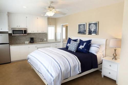 a bedroom with a bed with blue pillows and a kitchen at 1400 South Bayfront in Newport Beach