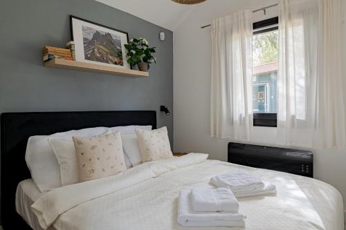 a bedroom with a white bed with two towels on it at Bodony Cottage in Bodony