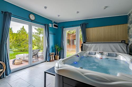 a large tub in a room with a patio at Bodony Cottage in Bodony