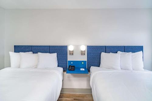 two beds in a room with blue and white at Micro Hotel in Conyers