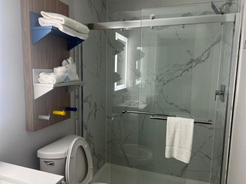 a bathroom with a glass shower with a toilet at Micro Hotel in Conyers