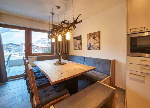 a dining room with a wooden table and a television at Appartements Der Fuchsbau in Saalbach Hinterglemm