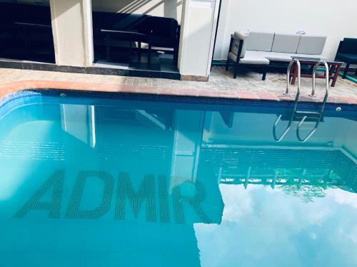 a view of a swimming pool with a bench and the water at Admiralty in Araromi