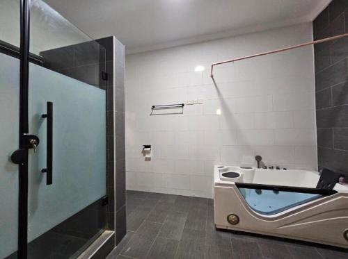 a bathroom with a shower and a bath tub at Admiralty in Araromi