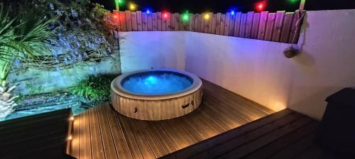 a bath tub sitting on a wooden deck with lights at Île d'Houat - Maison 5ch - 7 à 14 pers. - Piscine & S in La Turballe