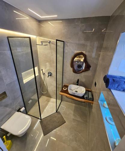 a bathroom with a shower and a toilet and a sink at Deluxe Apartment Delta Sharm in Sharm El Sheikh